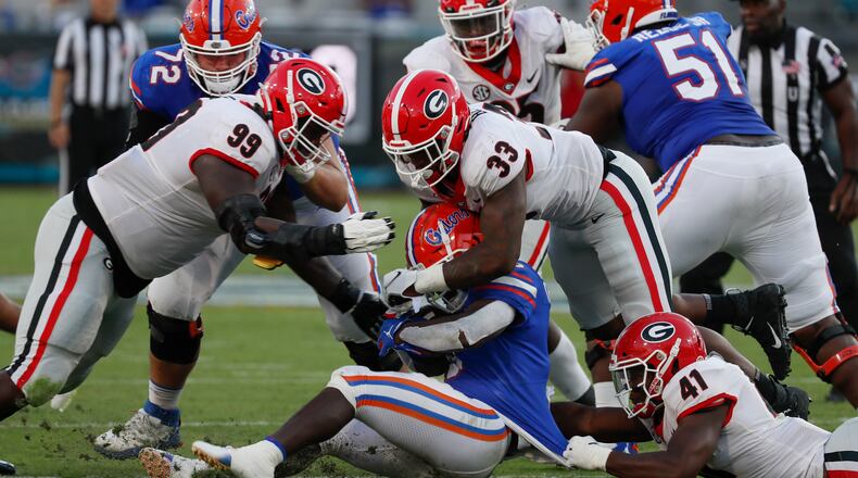 Florida Gators running back Nay'Quan Wright (6) stopped by Georgia Bulldogs defensive lineman Jordan Davis (99),Georgia Bulldogs linebacker Robert Beal Jr. (33) and Georgia Bulldogs linebacker Channing Tindall (41) during the second half of the annual NCCA Georgia vs Florida game at TIAA Bank Field in Jacksonville. Georgia won 34-7. Bob Andres / bandres@ajc.com
