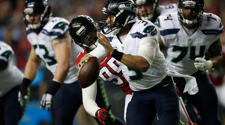 Atlanta Falcons defensive end Adrian Clayborn (99) pursues Seattle Seahawks quarterback Russell Wilson (3). Clayborn was lost on the third defensive snap in Saturday’s 36-20 playoff win over the Seahawks.