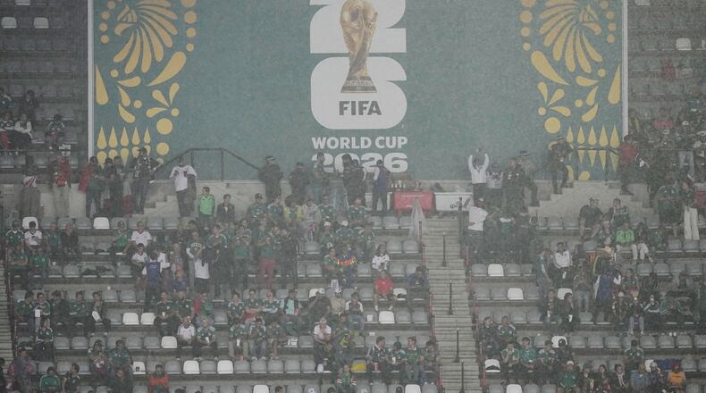 Fans wait out the rain as the game between Mexico and England is delayed due to weather for the World Cup round of 16 soccer match in Mexico City, Sunday, July 5, 2026. (AP Photo/Fernando Llano)
