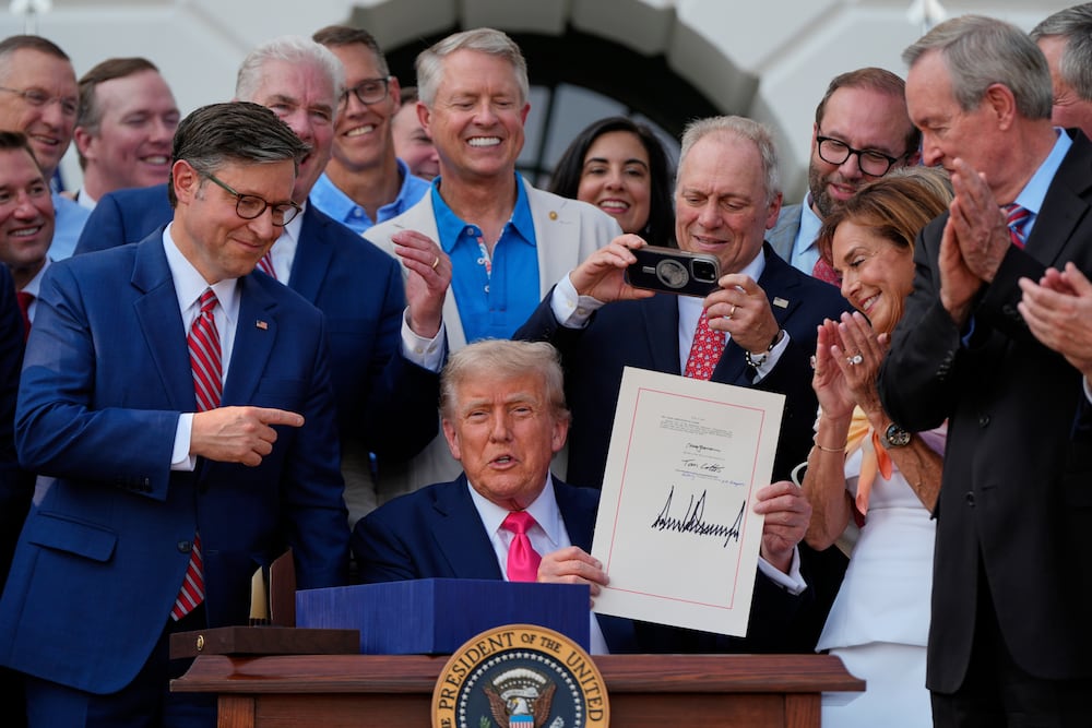 President Donald Trump celebrates the signing of tax breaks and spending cuts bill at the White House on Friday surrounded by Republican members of Congress.