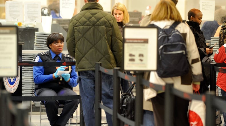 A TSA agent checks IDs and boarding passes of travelers making their way through a security checkpoint at Hartsfield-Jackson Atlanta International Airport in 2010. Credit: Bita Honarvar.