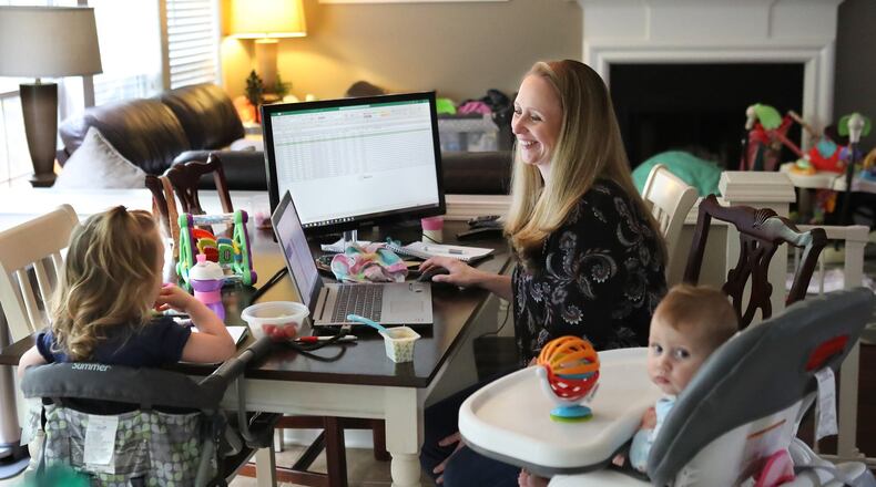Sam Gygax juggles decisions about product demand and supply as well as two young children, Josephine, 2, and Kathryn, 6 months, as she works in isolation from the kitchen of her Roswell home on Tuesday, April 7, 2020. Gygax is the demand planner for High Road Ice Cream. Curtis Compton ccompton@ajc.com
