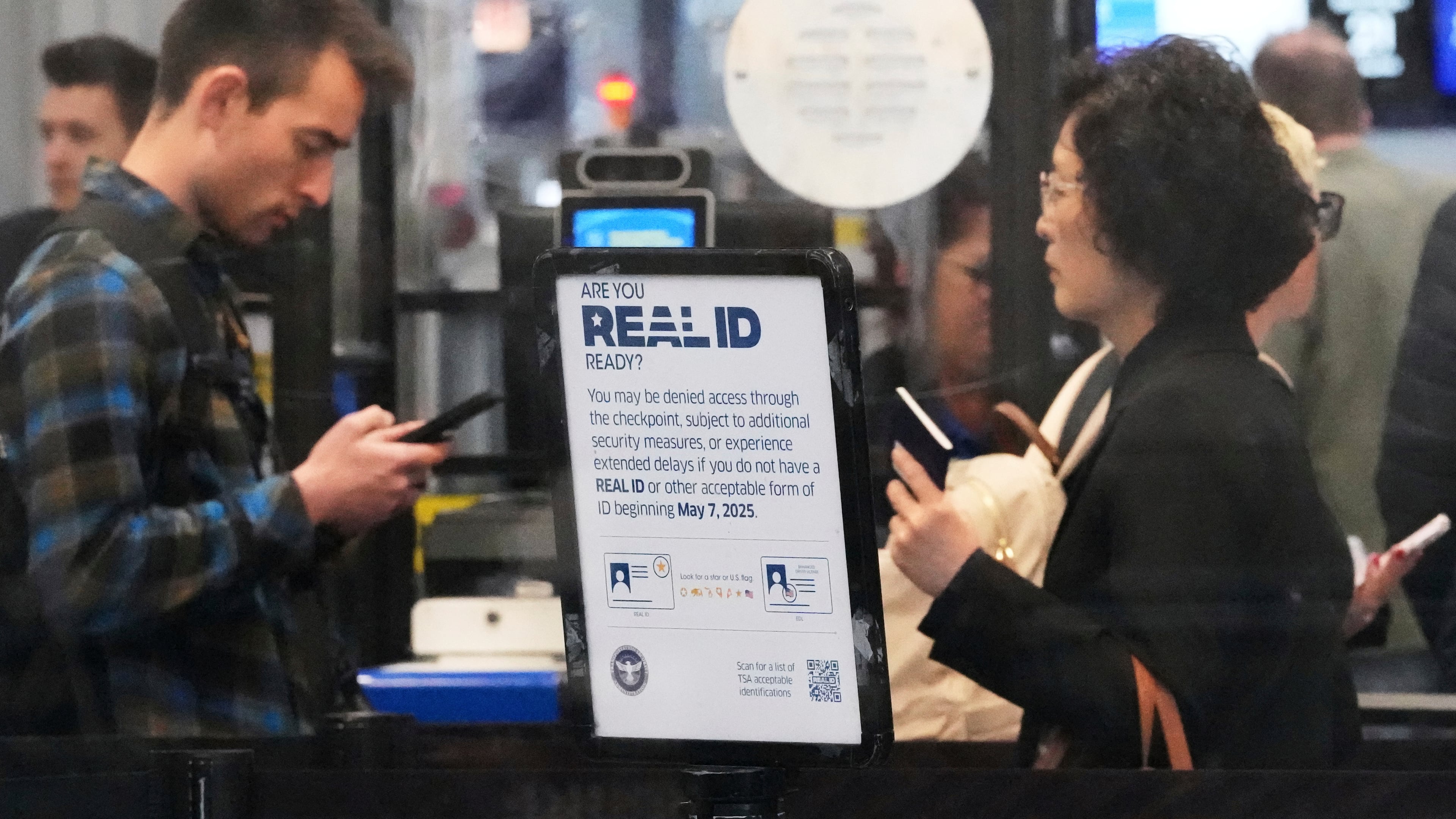 FILE - A Real ID sign is displayed as Travelers wait to go through security check point at O'Hare International Airport in Chicago, May 23, 2025. (AP Photo/Nam Y. Huh, File)