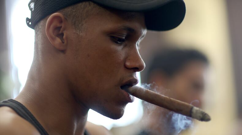 A worker smokes a cigar while making them in a cigar factory during the week-long International Habano Cigar Festival on February 26, 2015 in Havana, Cuba.