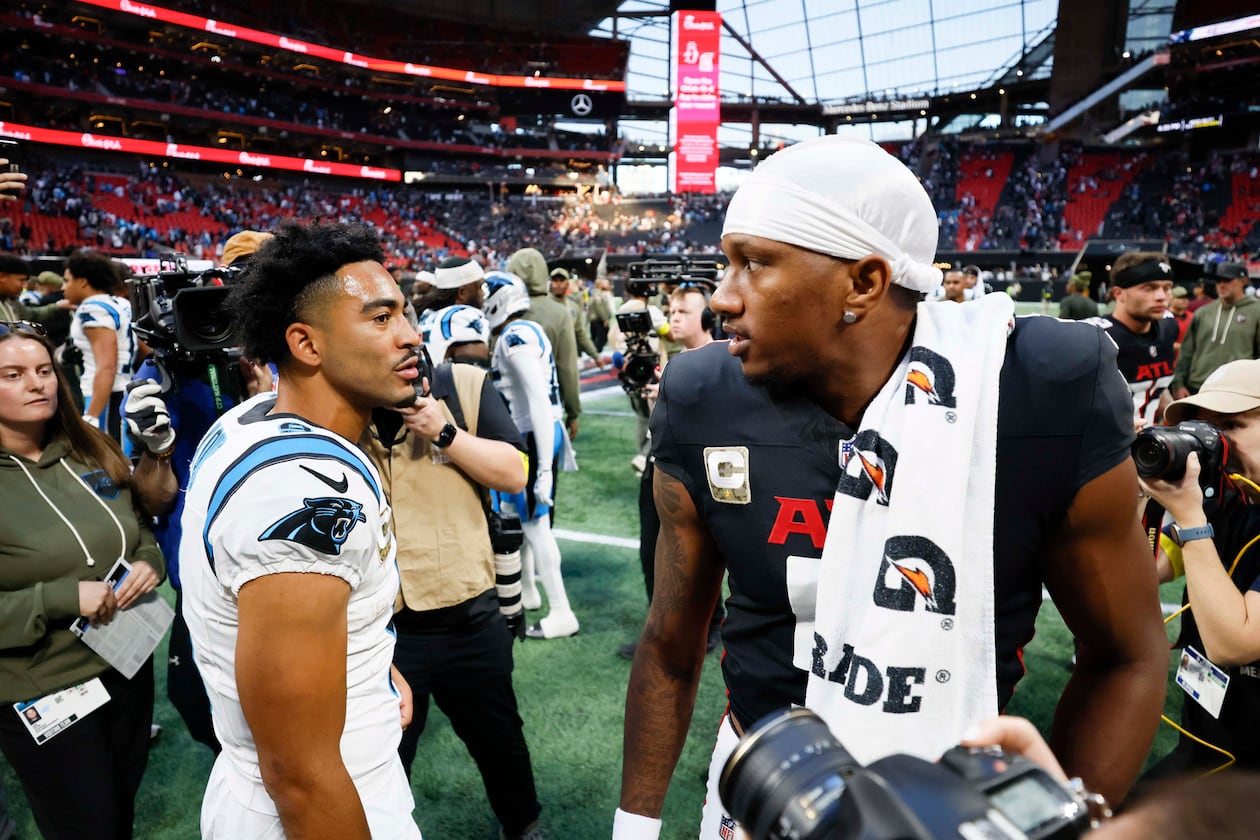 Atlanta Falcons quarterback Michael Penix Jr. (right) interacts with Carolina Panthers quarterback Bryce Young (left) at the end of the game. The Carolina Panthers defeated the Atlanta Falcons in overtime, 30-27, at Mercedes-Benz Stadium in Atlanta on Sunday, Nov. 16, 2025. (Miguel Martinez/AJC)