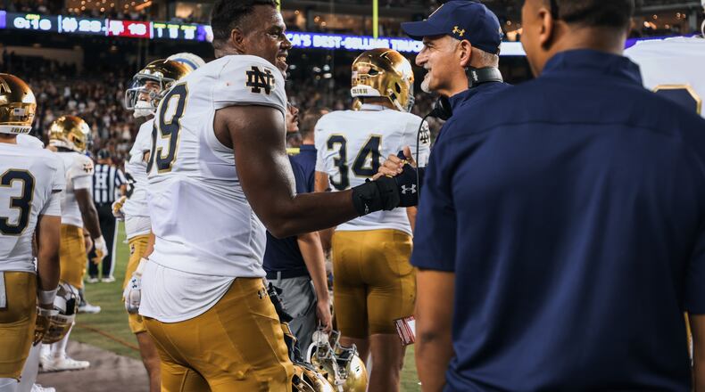 Notre Dame offensive lineman Aamil Wagner (center) shakes hands with offensive line coach Joe Rudolph during the Fighting Irish's Aug. 31, 2024 win over Texas A&M in College Station, Texas. (Notre Dame Athletics)