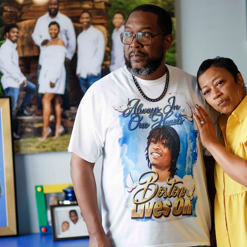 Ramonne and Terrica Thomas of Mableton, surrounded by images of their son, Boston Thomas. They're suing Cobb County to learn more about the events leading to their son's death. (Miguel Martinez/AJC)