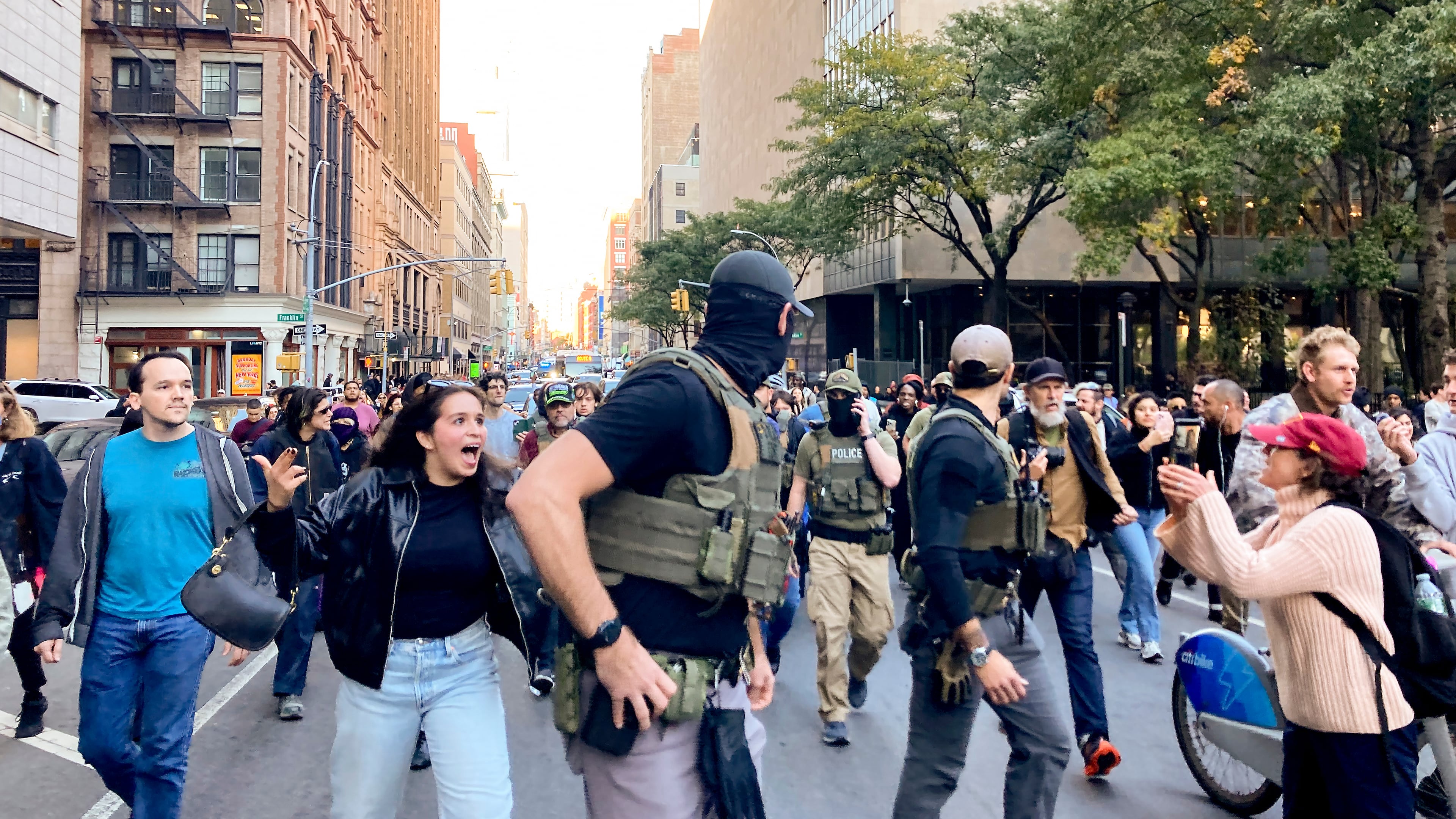Protestors confront Federal agents as they walk down Lafayette Street after an immigration sweep on Canal Street through Chinatown, Tuesday, Oct. 21, 2025, in New York. (AP Photo/Jake Offenhartz)