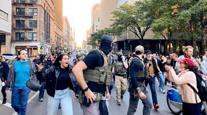 Protestors confront Federal agents as they walk down Lafayette Street after an immigration sweep on Canal Street through Chinatown, Tuesday, Oct. 21, 2025, in New York. (AP Photo/Jake Offenhartz)