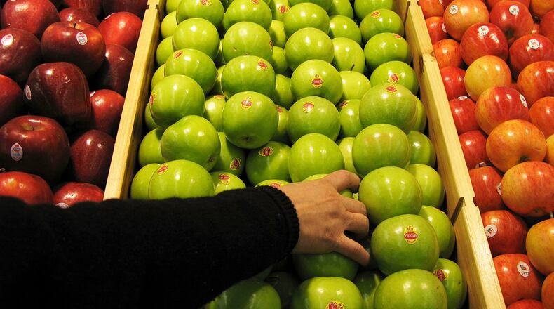 BEIJING - JANUARY 27: A shopper chooses granny smith apples at the newly-opened Tesco supermarket on January 27, 2007 in Beijing, China. The UK giant opened its first own-brand supermarket in Beijing after investing in 46 stores across China under the name of its Chinese partner, Le Gou, which translates as "Happy Shopping". Tesco's new store in Beijing is competing with other international chains that are well established in China, such as Wal-Mart and Carrefour. (Photo by Andrew Wong/Getty Images)