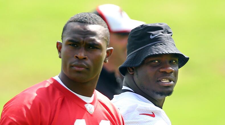 Falcons linebacker Sean Weatherspoon and wide receiver Julio Jones during team practice Tuesday, June 10, 2014, in Flowery Branch. Weatherspoon later left the field after rupturing his Achilles tendon. CURTIS COMPTON / CCOMPTON@AJC.COM