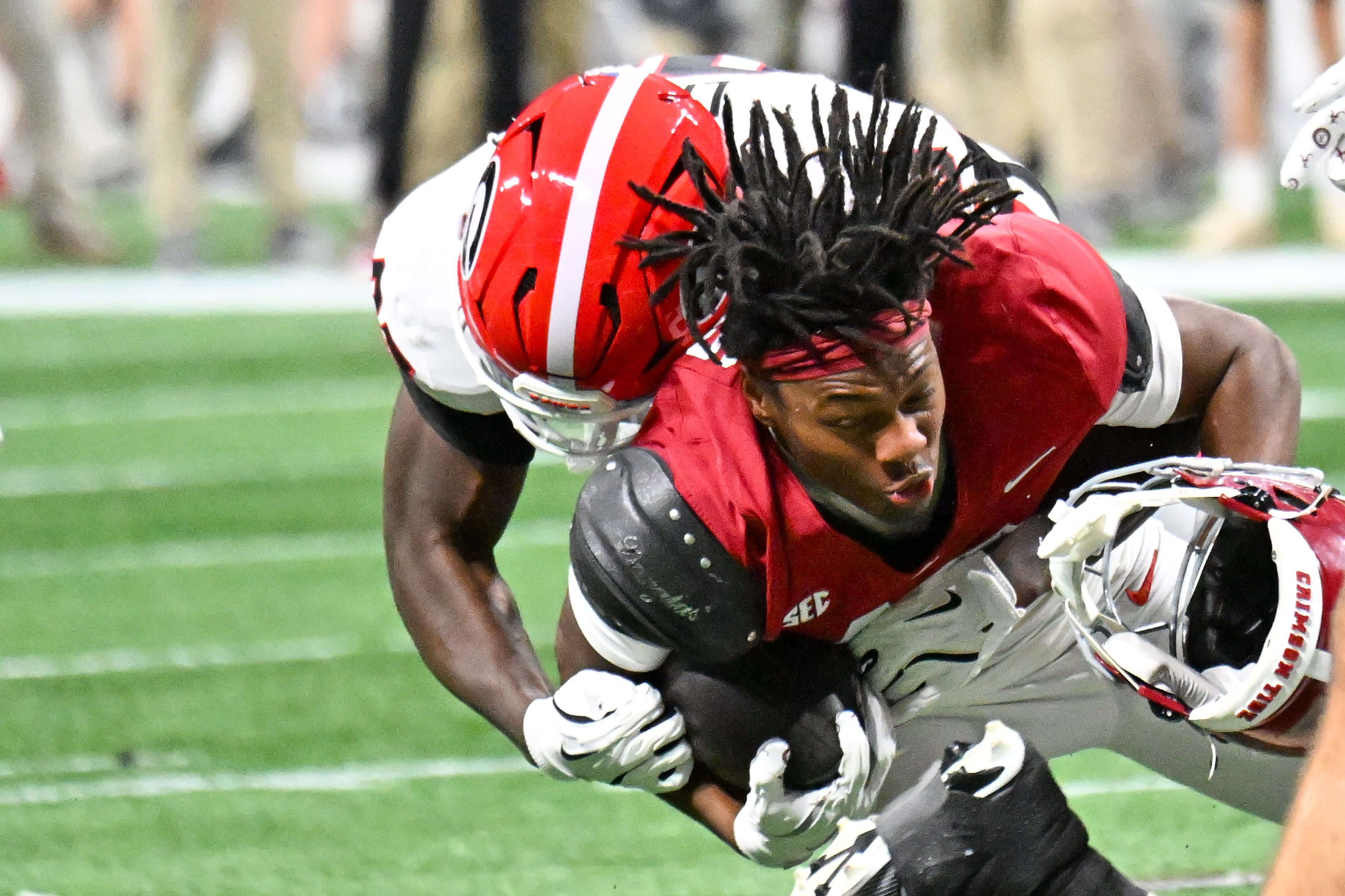 Alabama wide receiver Lotzeir Brooks (17) loses his helmet as Georgia linebacker Chase Linton (85) makes the tackle during the third quarter of the SEC Championship game at Mercedes-Benz Stadium, Saturday, Dec. 6, 2025, in Atlanta. (Hyosub Shin / AJC)