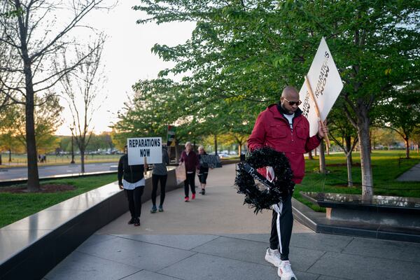 Pastor Robert Turner walks near the National Museum of African American History and Culture as part of his monthly walk from Baltimore to Washington to raise awareness of reparations on Wednesday, April 16, 2025, in Washington. (AP Photo/Nathan Howard)