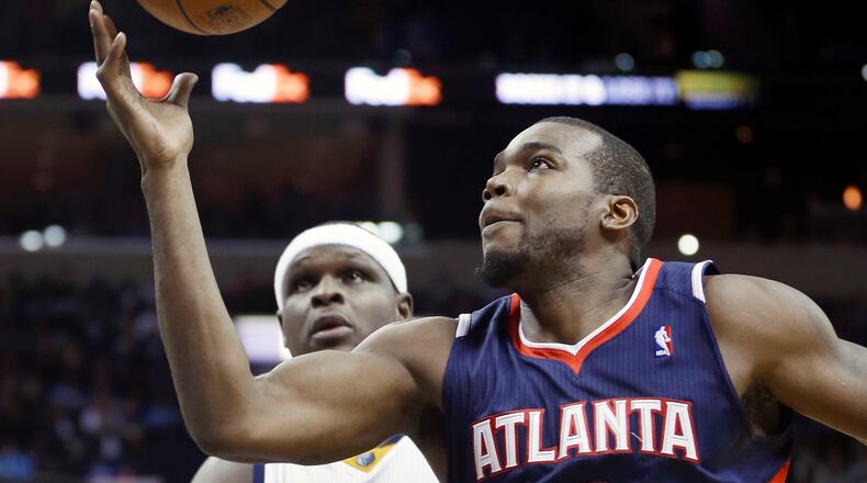 Atlanta Hawks' Paul Millsap (4) grabs a pass in front of Memphis Grizzlies' Zach Randolph (50) in the first half of an NBA basketball game in Memphis, Tenn., Sunday, Jan. 12, 2014. (AP Photo/Danny Johnston)