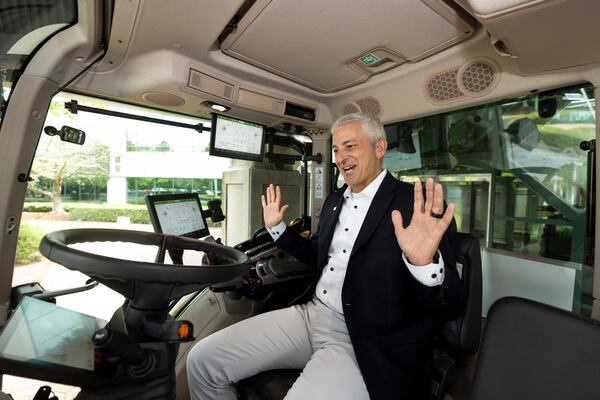 AGCO CEO Eric Hansotia demonstrates how to put the tractor in self-driving mode, in a Fendt 300 Vario tractor at the AGCO corporate headquarters in Duluth. The Fortune 500 company recently celebrated its 35 year anniversary. (Jason Getz/AJC)