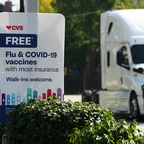 FILE - A sign for flu & COVID-19 vaccines is displayed outside a CVS store in Buffalo Grove, Ill., Sept. 23, 2025. (AP Photo/Nam Y. Huh, file)