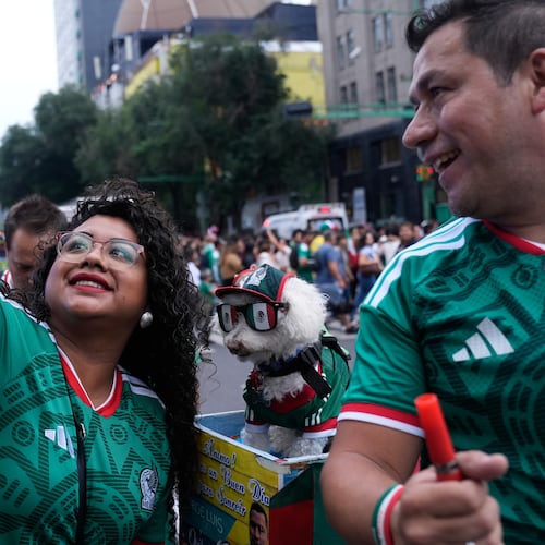 A fan, left, takes a photo with a dog named Osito, wearing a Mexico national soccer team jersey, next to Jorge Rangel before the World Cup Group A soccer match against South Korea in Mexico City, Thursday, June 18, 2026. (AP Photo/Marco Ugarte)