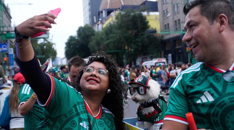 A fan, left, takes a photo with a dog named Osito, wearing a Mexico national soccer team jersey, next to Jorge Rangel before the World Cup Group A soccer match against South Korea in Mexico City, Thursday, June 18, 2026. (AP Photo/Marco Ugarte)