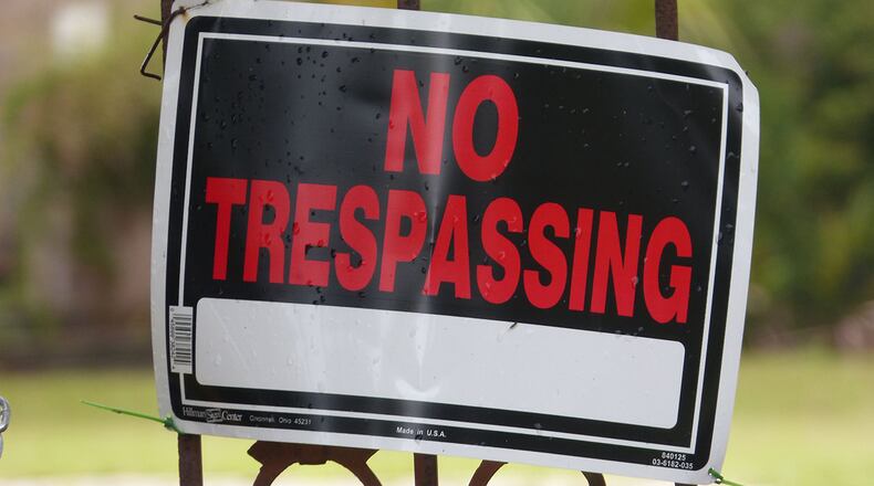 A Gwinnett County police officer took two “No Trespassing” signs off a Lawrenceville resident’s property.