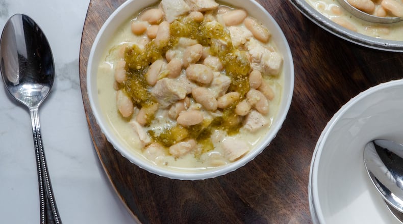 A hearty bowl of white chicken chili made with chicken breast, chicken stock, white beans, salsa verde and Neufchatel cheese. (Styling by Lori Horne / Virginia Willis for The Atlanta Journal-Constitution)