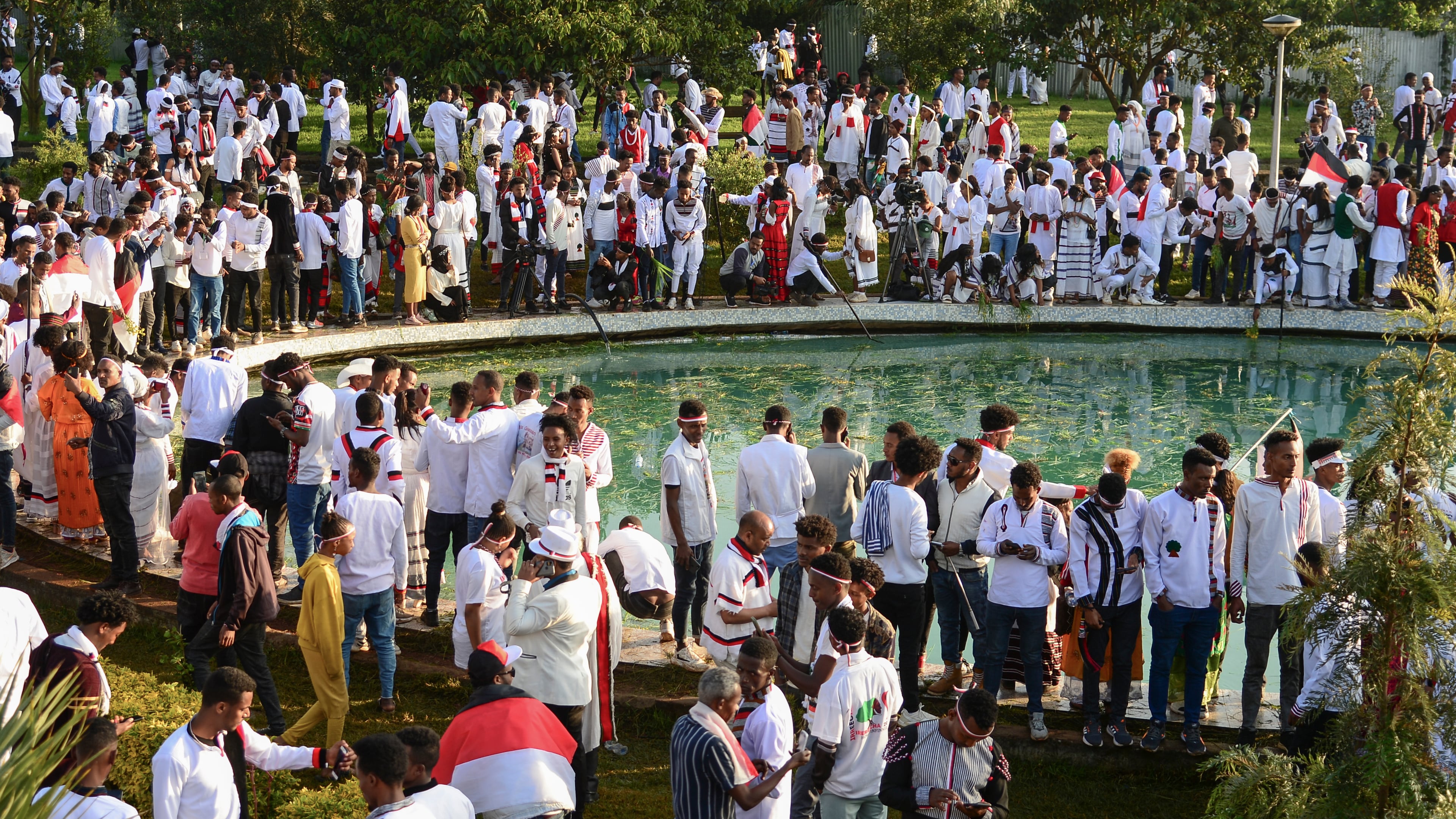 FILE - People throw grass and flowers into a pool of water as they celebrate the annual Irreecha festival in the capital Addis Ababa, Ethiopia, Oct. 1, 2022. (AP Photo/File)