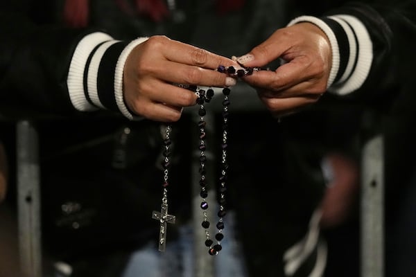 People attend a rosary prayer outside the Santa Maria Maggiore Basilica, where the late Pope Francis will be buried, in Rome, Thursday, April 24, 2025. (AP Photo/Andreea Alexandru)