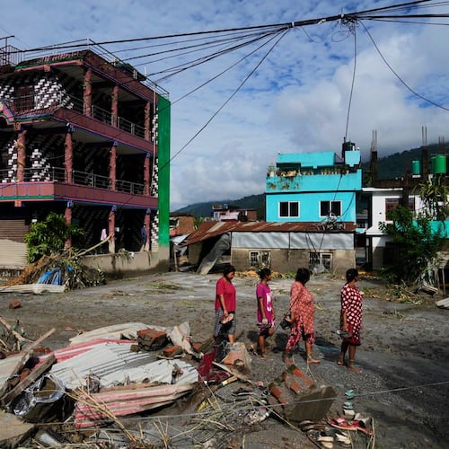 People walk past damage in the aftermath of flash floods in Devighat in the Nuwakot district in Nepal, Thursday, Aug 27, 2026. (AP Photo/Niranjan Shrestha)