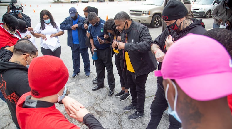 John Wilson, (center) pastor of the Gillem Community Church, prays with the volunteers before the start of the coat, blanket and gloves giveaway in Forest Park on Saturday, February 27, 2021. (Photo: Steve Schaefer for The Atlanta Journal-Constitution)