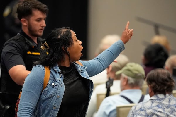 A protester is removed as Rep. Marjorie Taylor Greene, R-Ga., speaks during a town-hall style meeting, Tuesday, April 15, 2025, in Acworth, Ga. (AP Photo/Mike Stewart)
