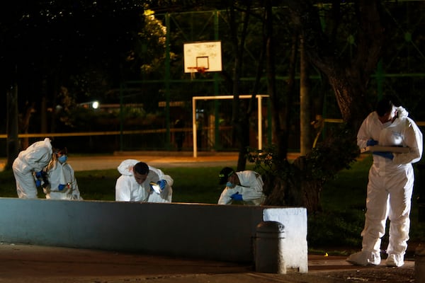 Investigators inspect the scene where Colombian senator and presidential candidate Miguel Uribe Turbay was shot during a campaign rally in Bogota, Colombia, Saturday, June 7, 2025. (AP Photo/Jhon Wilson Vizcaino)