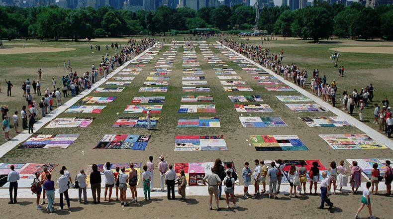 In 1988, people watch as almost 1,500 quilt panels bearing the names of New York area residents who died of AIDS are unfolded on the Great Lawn in New York’s Central Park. Author Jeff Graham says society’s early treatment of the HIV/AIDS crisis carries lessons for us today in the era of the coronavirus pandemic. (AP Photo/Wilbur Funches, File)