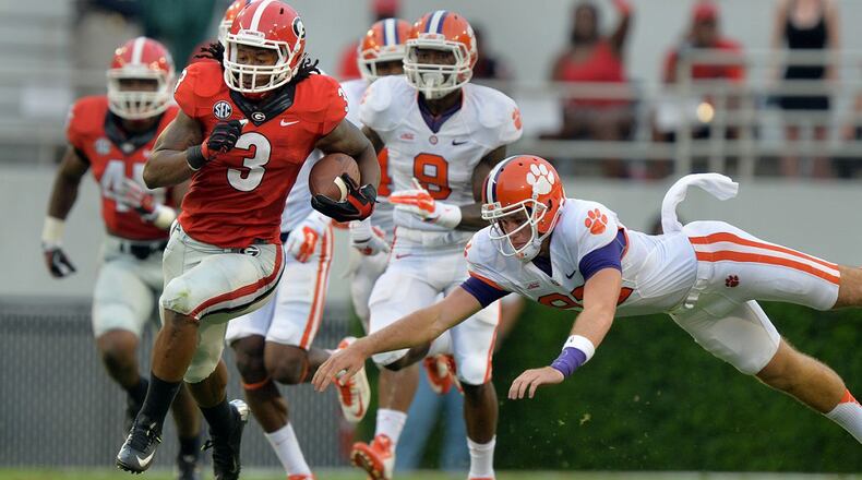Georgia running back Todd Gurley eludes the tackle of Clemson's Adrien Dunn en route to a 100-yard kickoff return against Clemson on Saturday, August 30, 2014 in Athens. BRANT SANDERLIN / AJC file
.