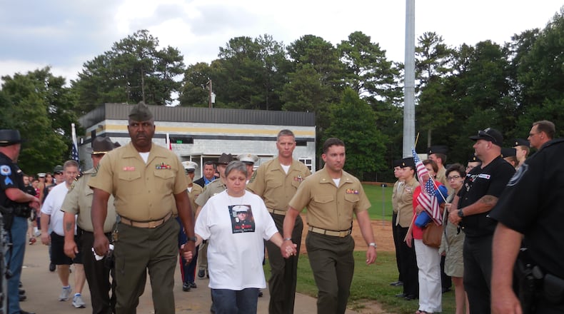 USMC Lance Cpl. Skip Wells' mother Cathy Wells is escorted into the stadium. Photo: Jennifer Brett