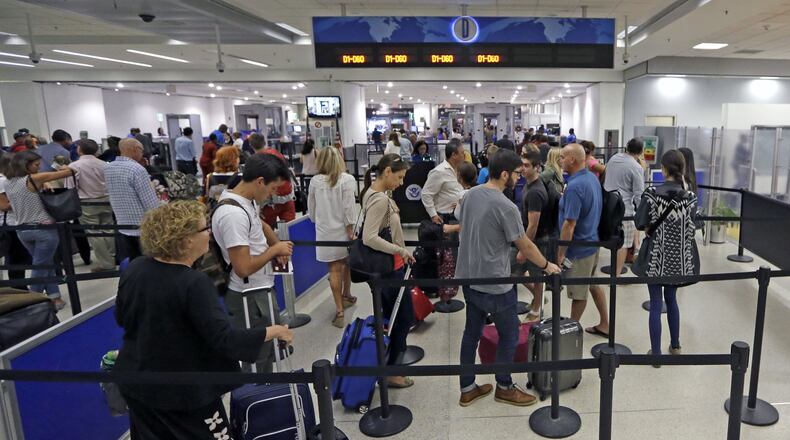 Travelers stand in line to pass through a TSA checkpoint at Miami International Airport on Thursday. (AP Photo/Alan Diaz)