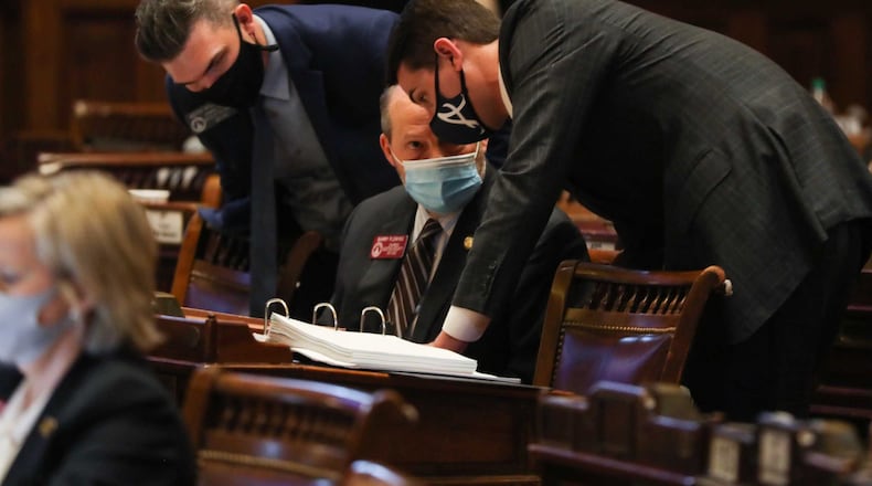 Rep. Trey Kelley, right, speaks with Rep. Barry Fleming, chairman of the Special Committee on Election Integrity, while debate on Senate Bill 202 takes place Thursday in the Georgia House. The measure to overhaul Georgia's election law won passage Thursday in both the House and Senate, and Gov. Brian Kemp signed it into law shortly after that. Alyssa Pointer / alyssa.pointer@ajc.com