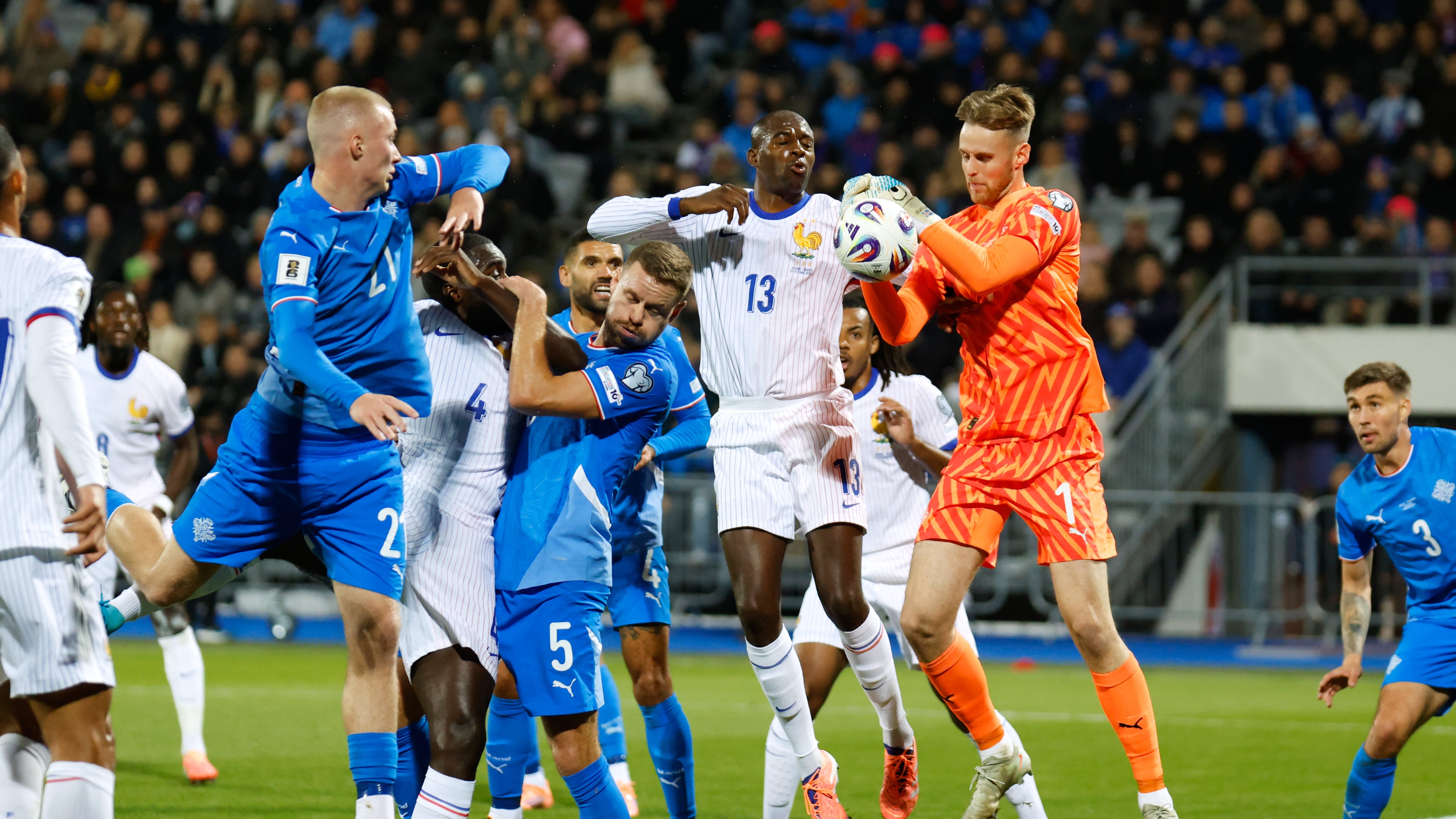 Iceland goalkeeper Elias Rafn Olafsson gets to the ball ahead of France's Jean-Philippe Mateta, center, during a World Cup 2026 group D qualifying soccer match between Iceland and France in Reykjavik, Monday, Oct. 13, 2025. (AP Photo/Brynjar Gunnarsson)