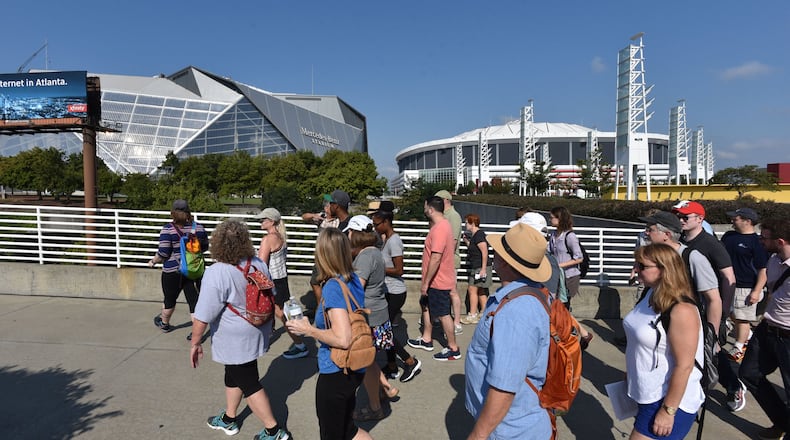 Tour participants depart from The Dome/GWCC/Philips Arena/CNN Center MARTA station for south Downtown/Underground Atlanta Walking Tour on Saturday, August 5, 2017. Falcons owner Arthur Blank and city leaders promised residents who live in the shadow of the new stadium that there were going to plenty of positive changes to their neighborhoods. HYOSUB SHIN / HSHIN@AJC.COM