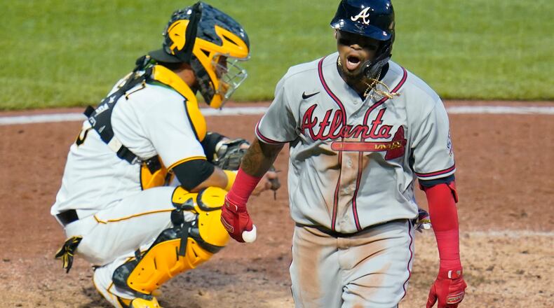 Braves' Orlando Arcia (right) returns to the dugout after hitting a solo home run off Pittsburgh Pirates starting pitcher Chad Kuhl in the fifth inning Tuesday, July 6, 2021, in Pittsburgh. (Gene J. Puskar/AP)