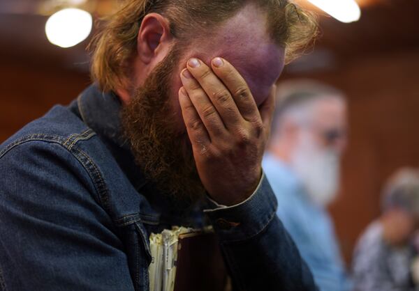 Isaac Green, 34, covers his eyes while praying before a Sacred Harp singing event at Holly Springs Primitive Baptist Church in Bremen, Ga., on Sunday, March 23, 2025. (AP Photo/Jessie Wardarski)