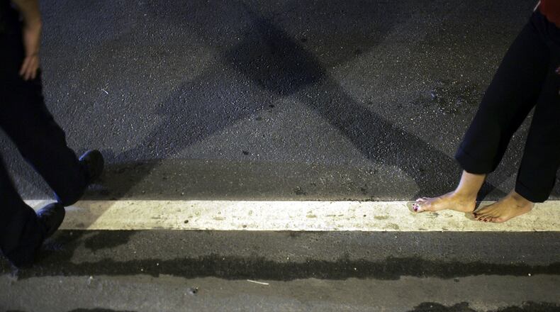 Officer Kevin Millan from the City of Miami Beach police department instructs a woman how to walk the white line during a field sobriety test at a DUI checkpoint December 15, 2006 in Miami, Florida. (Photo by Joe Raedle/Getty Images)