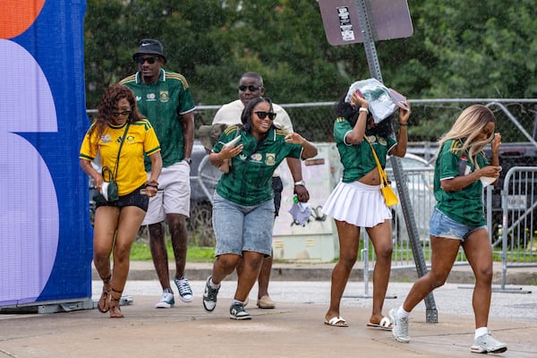 South Africa fans run in the rain before their team plays in Atlanta on Thursday, June 18, 2026. (Ben Hendren for the AJC)
