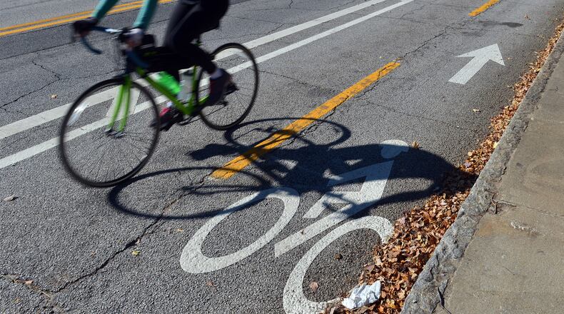 COVER November 4, 2013 Atlanta: A cyclist travels in the designated bike lane on 10th Street Monday morning. The two-way bicycle lane on 10th street opened in August . BRANT SANDERLIN /BSANDERLIN@AJC.COM