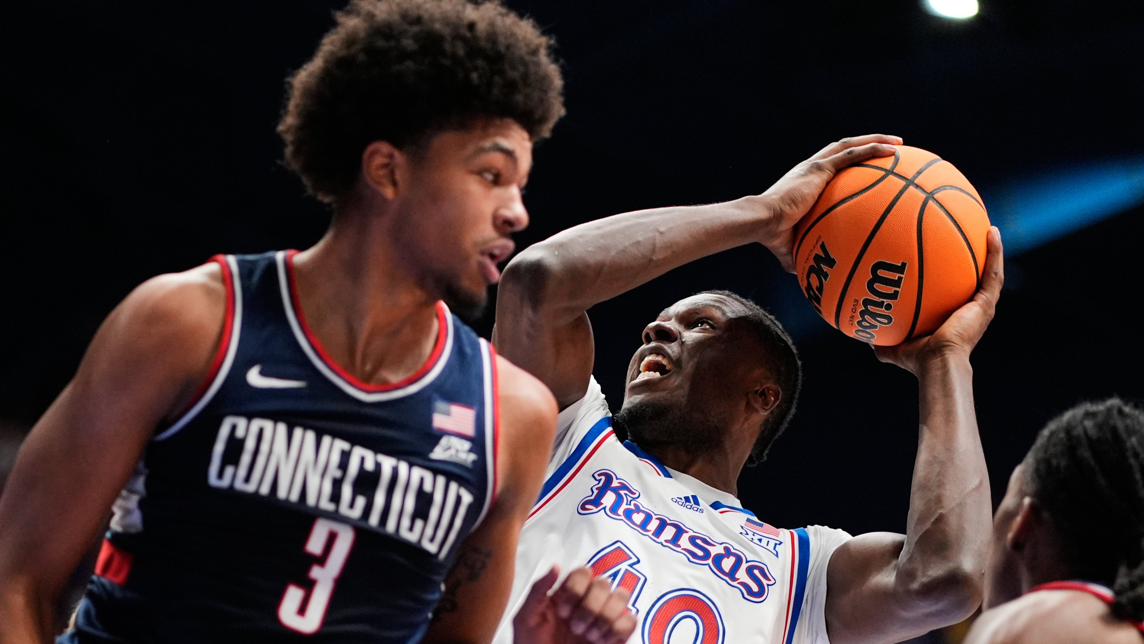 Kansas forward Flory Bidunga (40) shoots over UConn forward Jaylin Stewart (3) during the first half of an NCAA college basketball game Tuesday, Dec. 2, 2025, in Lawrence, Kan. (AP Photo/Charlie Riedel)