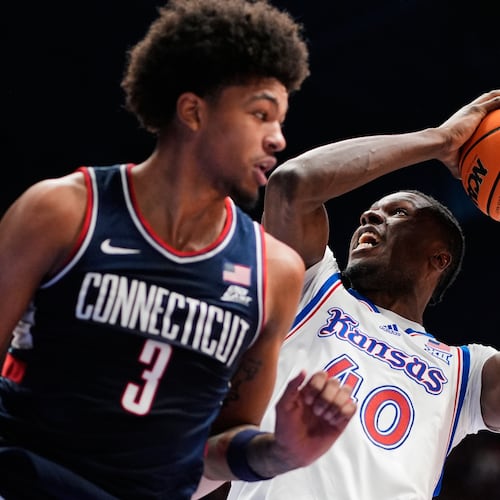 Kansas forward Flory Bidunga (40) shoots over UConn forward Jaylin Stewart (3) during the first half of an NCAA college basketball game Tuesday, Dec. 2, 2025, in Lawrence, Kan. (AP Photo/Charlie Riedel)
