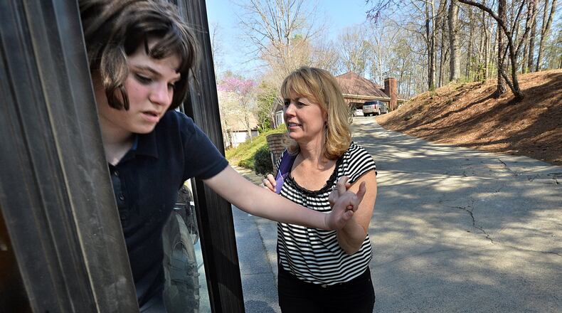 Patti Grayson helps her daughter Caroline, 12, who has autism, getting off from a school bus near their home in Sandy Springs on Tuesday, April 1, 2014. Some of Georgia’s most severely disabled students are bussed long distances to go to schools outside their communities that offer specialized programs supporting their needs. Students with disabilities and their parents often feel disconnected to their communities when they have to travel great distances to attend school. In Fulton County, students with disabilities often must ride a bus more than an hour to attend specialized programs at schools. HYOSUB SHIN / HSHIN@AJC.COM