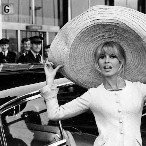 FILE - French actress Brigitte Bardot poses with a huge sombrero she brought back from Mexico, as she arrives at Orly Airport in Paris, France, on May 27, 1965. (AP Photo/File)
