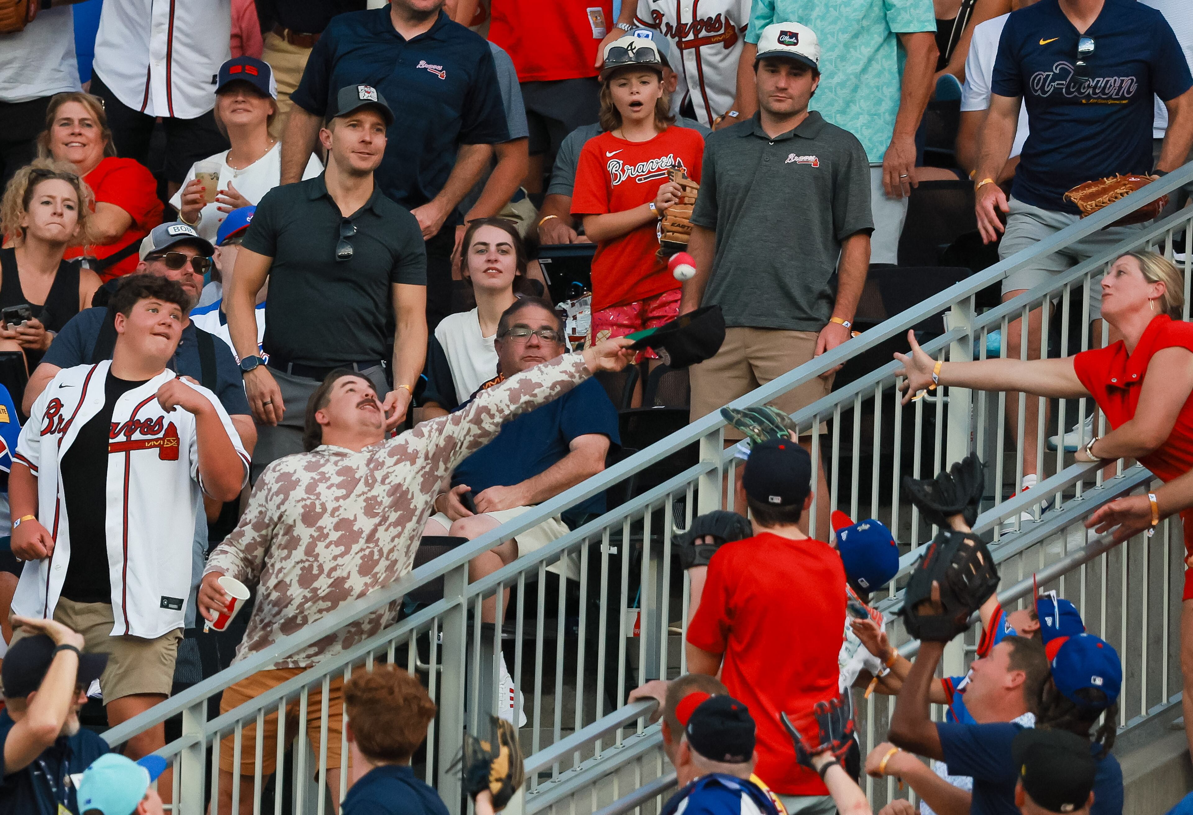 Baseball fans reach for a ball hit by Washington Nationals left fielder James Wood during the MLB Home Run Derby as part of the All-Star Game festivities on Monday, July 14, 2025 at Truist Park in Atlanta. Jason Getz / AJC