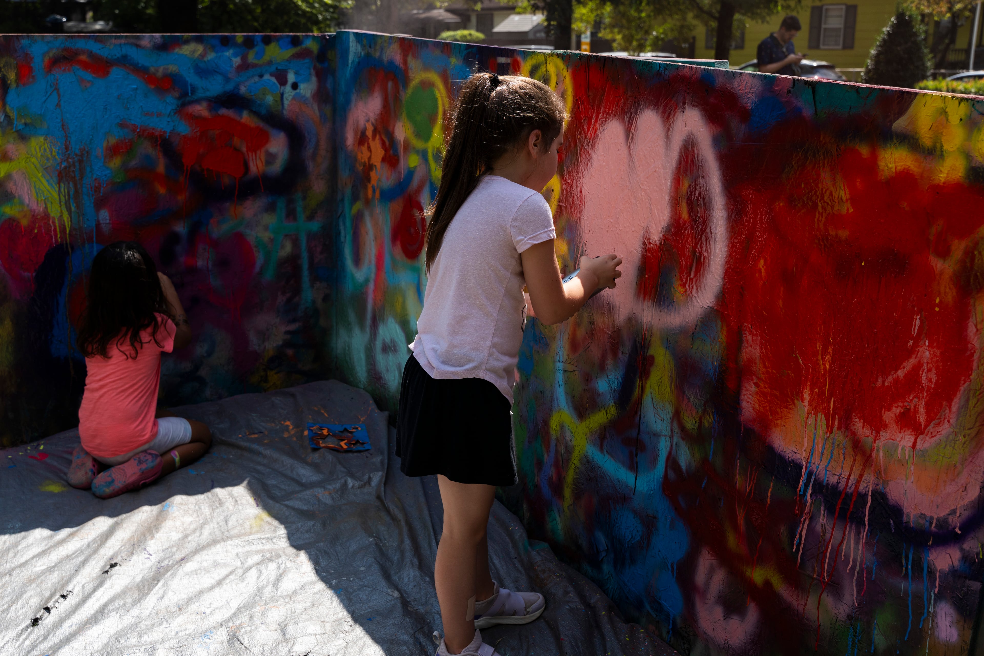 Kids paint with spray paint at the 11th annual Forward Warrior festival in the Cabbagetown neighborhood of Atlanta on Saturday, Sept. 13, 2025. (Olivia Bowdoin for the AJC)