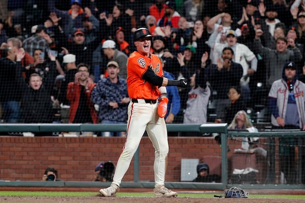 San Francisco Giants second baseman Tyler Fitzgerald (49) celebrates scoring from third base on a wild pitch by Atlanta Braves pitcher Pierce Johnson (38) in the 10th inning of a baseball game at Oracle Park in San Francisco, Friday, June 6, 2025. (Santiago Mejia/San Francisco Chronicle via AP)