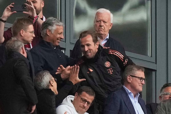 Bayern's Harry Kane, center, arrives on the tribune ahead of the German Bundesliga soccer match between RB Leipzig and FC Bayern Munich at the Red Bull Arena in Leipzig, Germany, Saturday, May 3, 2025. (AP Photo/Matthias Schrader)